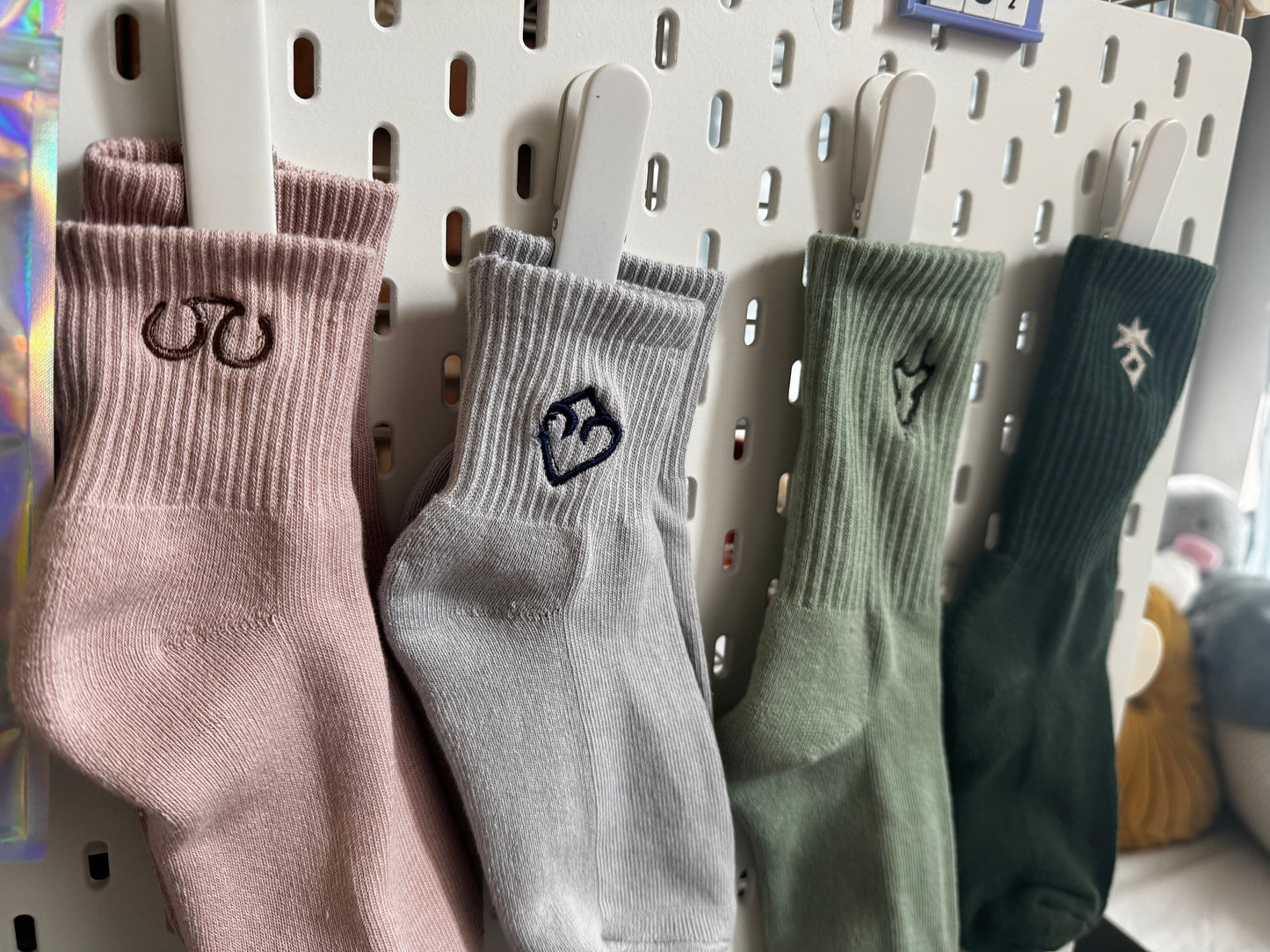 Four pairs of socks hanging on a pegboard with ff logo designs.