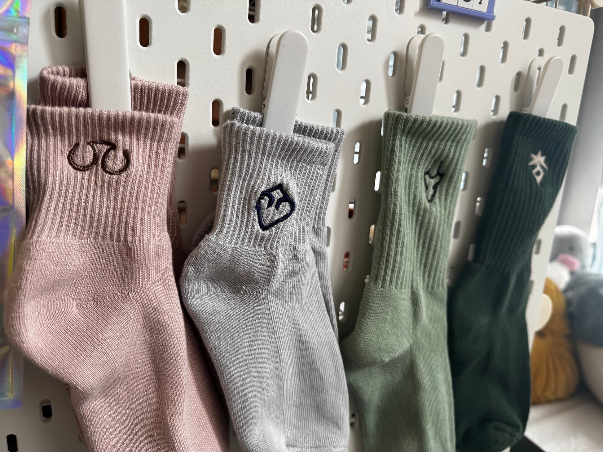 Four pairs of socks hanging on a pegboard with ff logo designs.
